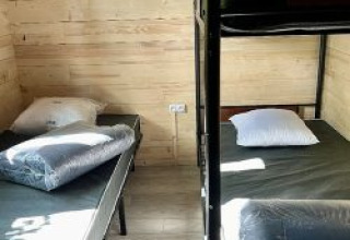 Camera con due letti singoli e un letto a castello in uno chalet al Camping La Grande Véyière, Francia.