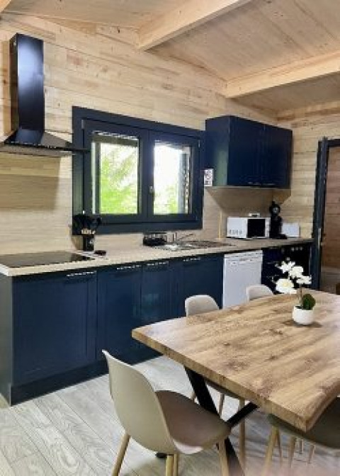 Cucina moderna e zona pranzo nello Chalet al Campeggio La Grande Véyière, Francia, con arredo in legno.