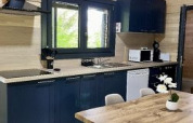 Cucina moderna e zona pranzo nello Chalet al Campeggio La Grande Véyière, Francia, con arredo in legno.
