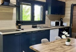 Cucina moderna e zona pranzo nello Chalet al Campeggio La Grande Véyière, Francia, con arredo in legno.