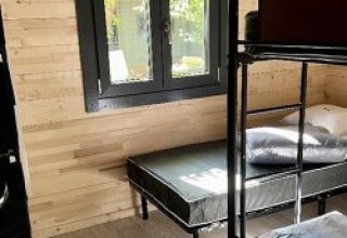 Camera con letti a castello e finestra nello Chalet al Campeggio La Grande Véyière in Francia, pareti in legno.