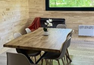 Eethoek in Chalet op Camping La Grande Véyière, Frankrijk, met houten interieur en modern meubilair.