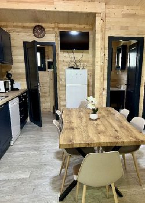 Knusse eetruimte in een chalet bij Camping La Grande Véyière, Frankrijk, met houten wanden en modern interieur.