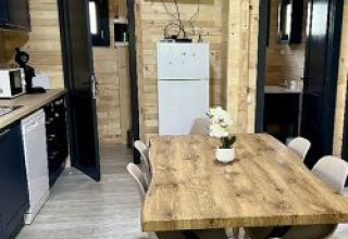 Accogliente zona pranzo in uno chalet al campeggio La Grande Véyière, Francia, con arredamento moderno e legno.