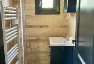 Badkamer in chalet op camping La Grande Véyière, Frankrijk, met houten wanden en moderne voorzieningen.