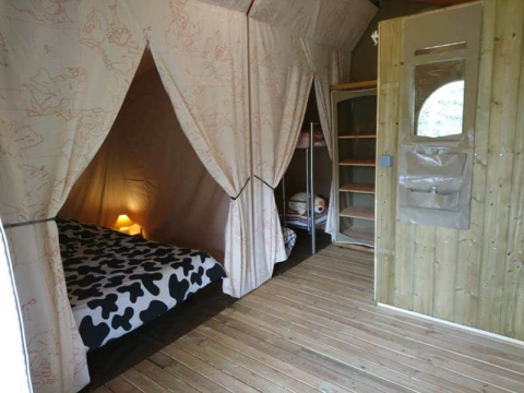 Interno del Lodge Canada Comfort, tenda safari al campeggio La Grande Véyière in Francia, con letti accoglienti.