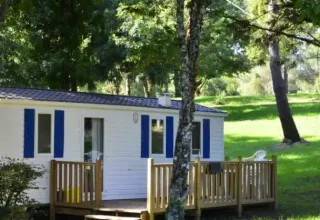 Mobile Home Comfort am Campingplatz La Grande Véyière in Frankreich, umgeben von Bäumen und Natur.