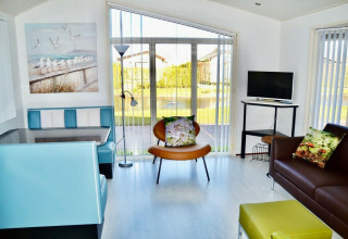 Lys stue i hytten Comfort 4 personer MIVA ved De Woudhoeve, Holland, med moderne møbler og panoramaudsigt.