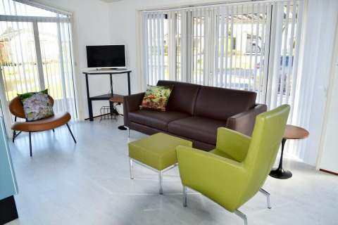 Lyst opholdsområde i Comfort 4 personen MIVA-hytten på De Woudhoeve, moderne møbler og store vinduer.