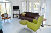 Lyst opholdsområde i Comfort 4 personen MIVA-hytten på De Woudhoeve, moderne møbler og store vinduer.
