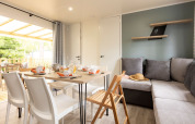 Helles Wohn- und Esszimmer im Mobile Home Premium auf Flower Camping Le Vieux Moulin mit moderner Einrichtung.