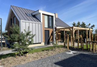 Modern lodge named Duinvilla at EuroParcs Texel in the Netherlands, featuring sleek design and garden.