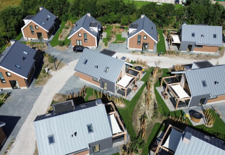 Aerial view of Duinvilla Wellness lodge with modern cabins, green lawns, pathways, and a peaceful setting.