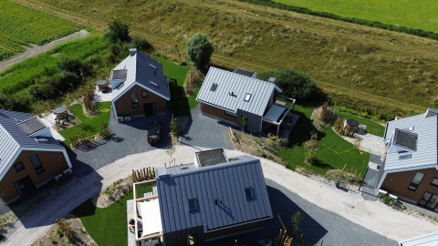 Aerial view of Duinvilla Wellness lodge, featuring modern cabins, green spaces, and outdoor relaxation areas.