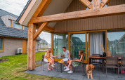 Familia disfrutando en la terraza de EuroParcs Cadzand-Bad, un parque vacacional en Zeeland, Países Bajos.