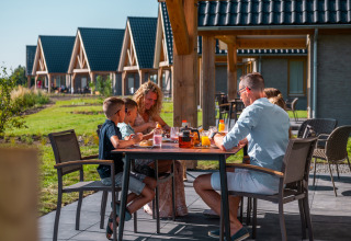 Famiglia che fa colazione all’aperto a EuroParcs Cadzand-Bad, villaggio vacanze in Zelanda, Paesi Bassi.