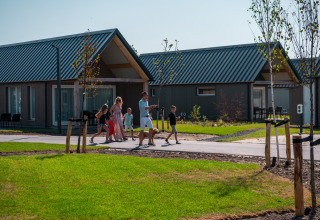 Famiglia passeggia davanti alle case vacanza di EuroParcs Cadzand-Bad, villaggio turistico in Zelanda, Paesi Bassi.