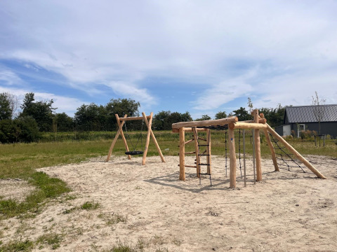 Playground with wooden swings and climbing frame at EuroParcs Cadzand-Bad in Zeeland, Netherlands.