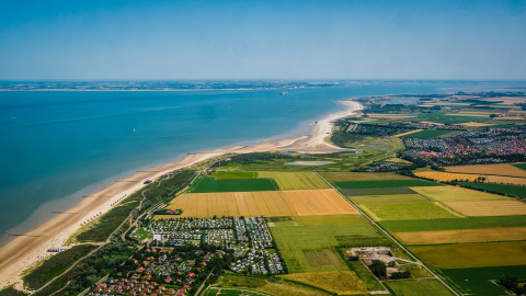 Aerial view of the coast near Cadzand, Zeeland, Netherlands with beaches, farmland, and towns nearby.