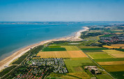 Aerial view of the coast near Cadzand, Zeeland, Netherlands with beaches, farmland, and towns nearby.