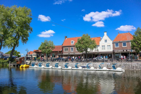 Vista de botes de pedales en un canal y casas típicas en Nieuwvliet, Zeeland, Países Bajos.