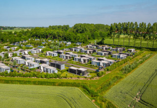 Aerial view of EuroParcs Bad Meersee holiday park in Zeeland, Netherlands, featuring modern cabins and greenery.