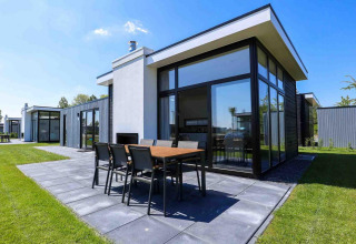 Moderne Ferienvilla mit Terrasse im EuroParcs Bad Meersee in Zeeland, Niederlande, an einem sonnigen Tag.