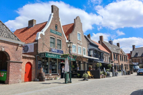 Straat in Nieuwvliet, Zeeland met typische Hollandse gevelhuizen en gezellige terrassen en cafés.