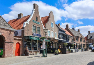 Straat in Nieuwvliet, Zeeland met typische Hollandse gevelhuizen en gezellige terrassen en cafés.