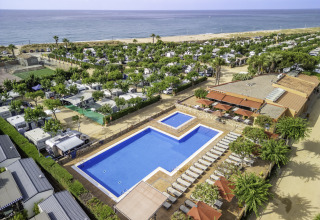 Aerial view of pool, sun loungers, mobile homes, and the beach at Campsite del Mar in Catalonia, Spain.