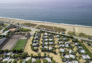 Aerial view of Campsite del Mar in Catalonia, Spain, showing motorhomes and pitches by the seaside beach.