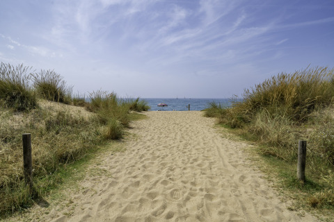 Sandy path through dunes leading to the sea at Campsite del Mar, a holiday park in Catalonia, Spain.