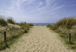 Sandy path through dunes leading to the sea at Campsite del Mar, a holiday park in Catalonia, Spain.