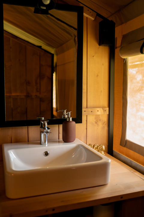 Évier de salle de bain rustique et miroir dans une tente safari Forest Lodge, Jocomo Parc, Belgique.