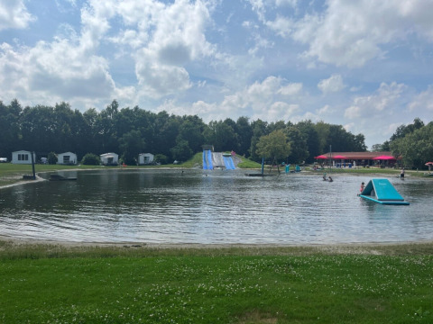 Lake with waterslide and holiday cabins at Campsite de Bouwte holiday park, Groningen, Netherlands.