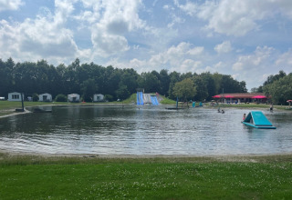 Lake with waterslide and holiday cabins at Campsite de Bouwte holiday park, Groningen, Netherlands.