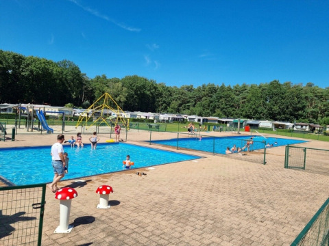Families enjoy sunny weather at the swimming pools in Campsite San Lanaco, Limburg, Belgium holiday park.