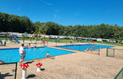 Families enjoy sunny weather at the swimming pools in Campsite San Lanaco, Limburg, Belgium holiday park.