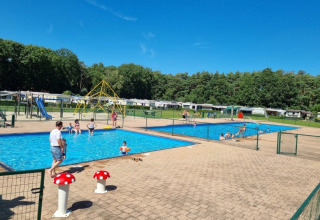 Families enjoy sunny weather at the swimming pools in Campsite San Lanaco, Limburg, Belgium holiday park.
