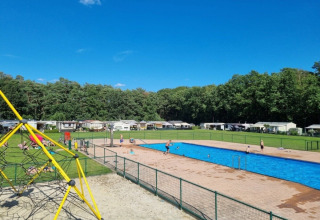 Piscina all'aperto e parco giochi al campeggio San Lanaco immersi nel verde del Limburgo belga.