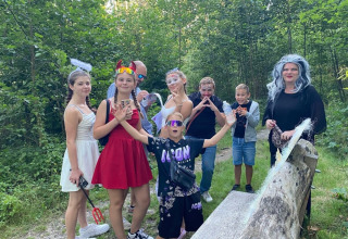 Kids and adults in costumes enjoying festivities at Campsite San Lanaco, Belgian Limburg, in the woods.