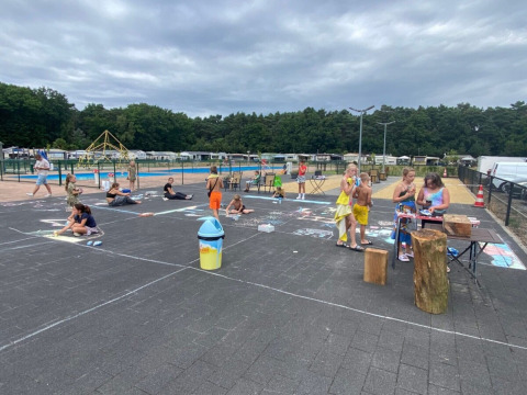 Children draw with chalk and play outside at Campsite San Lanaco holiday park in Limburg, Belgium.
