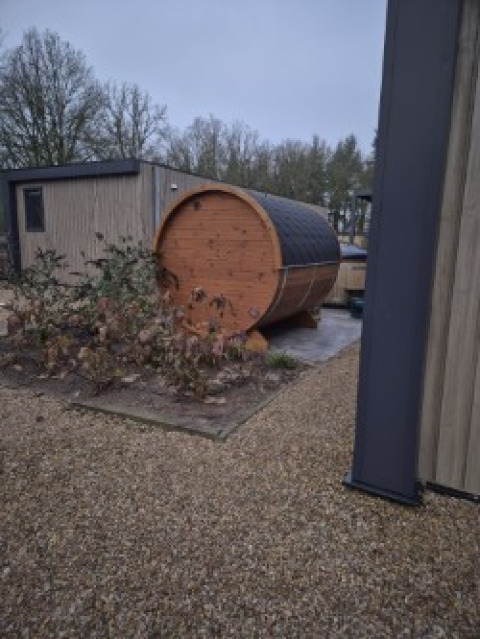 Vue extérieure d’un sauna en forme de tonneau près du lodge Batenburgh Deluxe au parc Veluwe de Bosgraaf, Pays-Bas.
