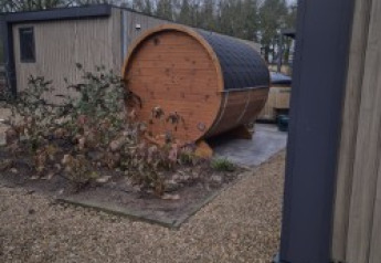 Udendørs billede af en tøndeformet sauna ved siden af en lodge, Batenburgh Deluxe, på Veluwe park de Bosgraaf.