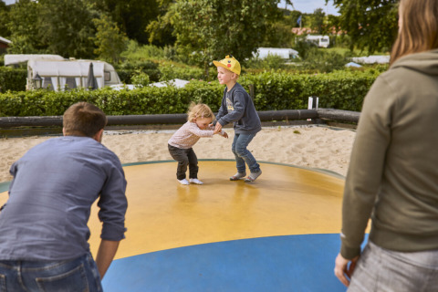 Kinder spielen auf einem aufblasbaren Trampolin bei Emmerbølle Strand Camping in Süddänemark.