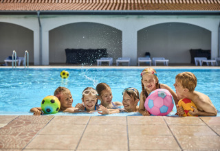 Bambini che giocano con palloni colorati nella piscina di Emmerbølle Strand Camping, Danimarca meridionale.