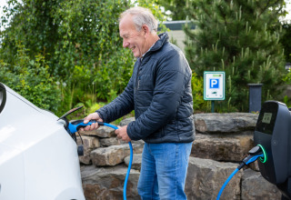 Man charges electric car at a charging station at Campsite Roland, a holiday park in Limburg, Netherlands.