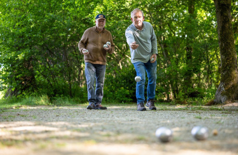 Due uomini anziani giocano a pétanque all'aperto nel campeggio Roland a Limburg, Paesi Bassi.