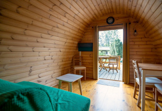 Innenraum eines kleinen Pod-Hauses auf dem Campingplatz Roland in den Niederlanden mit Terrassenblick.