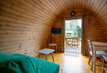 Intérieur d'une tiny house de type pod au Camping Roland aux Pays-Bas, vue sur la terrasse extérieure.